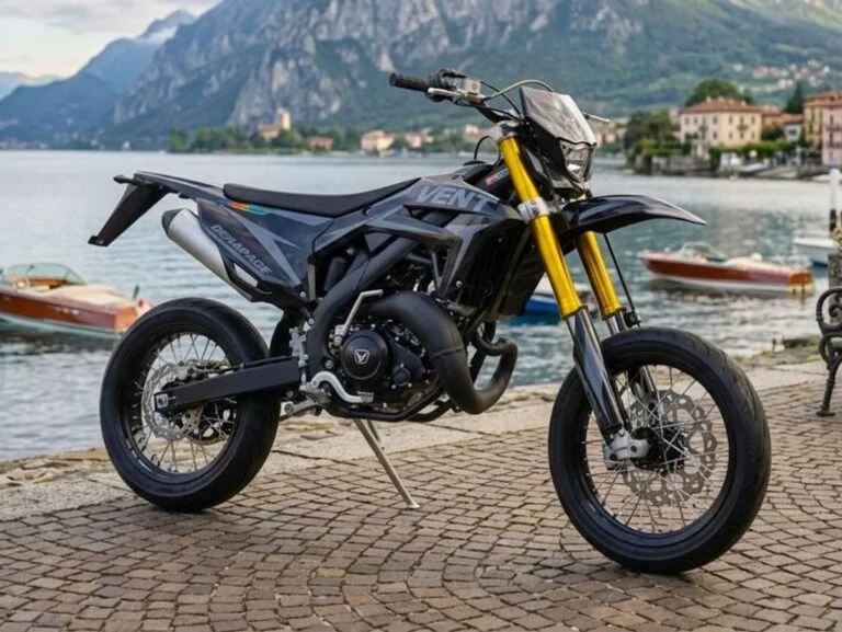 Vent Dérapage Black Edition, uma supermoto de edição limitada, exibindo seu design predominantemente preto fosco com detalhes em grafismos discretos e rodas pretas, destacando a agilidade e o estilo esportivo. A moto está estacionada em um ambiente urbano, com iluminação que realça suas linhas agressivas.
