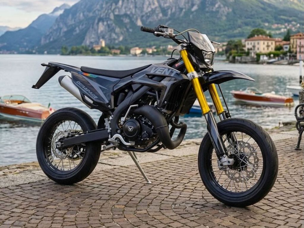 Vent Dérapage Black Edition, uma supermoto de edição limitada, exibindo seu design predominantemente preto fosco com detalhes em grafismos discretos e rodas pretas, destacando a agilidade e o estilo esportivo. A moto está estacionada em um ambiente urbano, com iluminação que realça suas linhas agressivas.