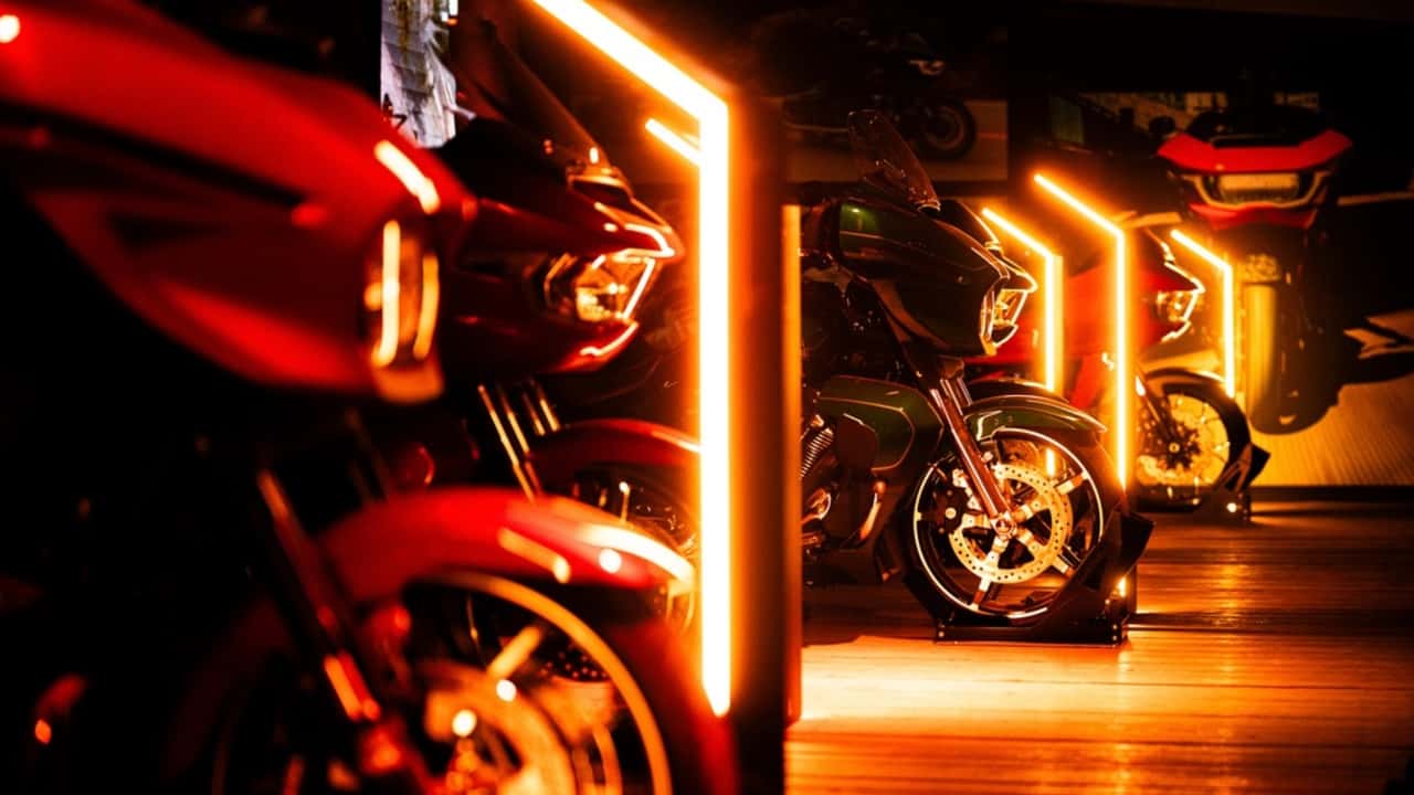 Dezenas de motocicletas Harley-Davidson estacionadas em fila ao longo da costa croata, com motociclistas reunidos e apreciando a vista do Mar Adriático sob um céu ensolarado durante o H.O.G. Rally.