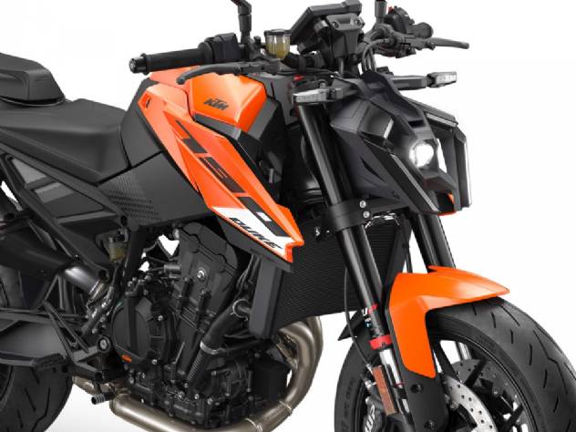 KTM 790 Duke 2027 estacionada em ambiente urbano, destacando seu design agressivo, farol LED e rodas laranja características da marca.