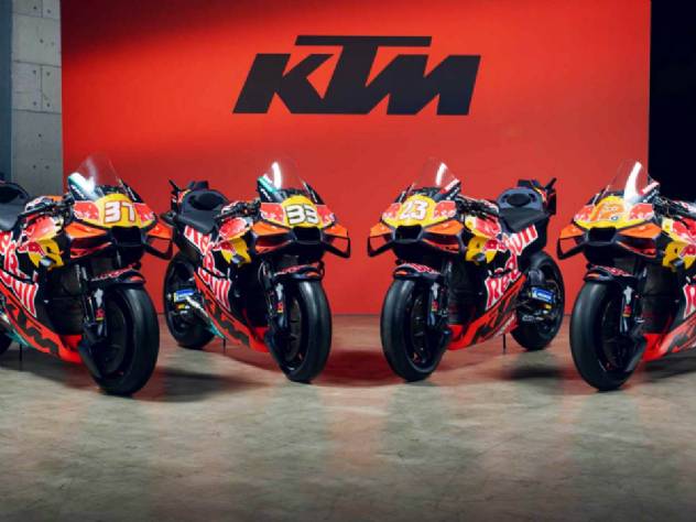 Moto KTM RC16 competindo em alta velocidade em uma pista de MotoGP, demonstrando a tecnologia e o desempenho da equipe.