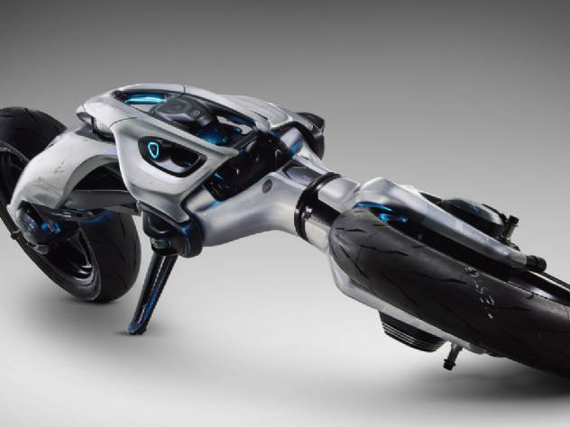 Close-up do conceito Yamaha MOTOROiD, uma motocicleta futurista com design elegante e autônoma, destacando sua tecnologia de inteligência artificial e o sistema de auto-equilíbrio, com iluminação em azul e superfícies metálicas.