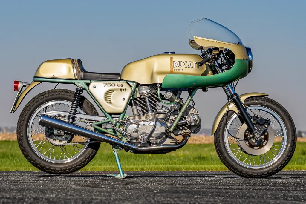 Ducati 750 SS Green Frame de 1974 em exposição, destacando seu chassi verde oliva e design clássico de corrida.