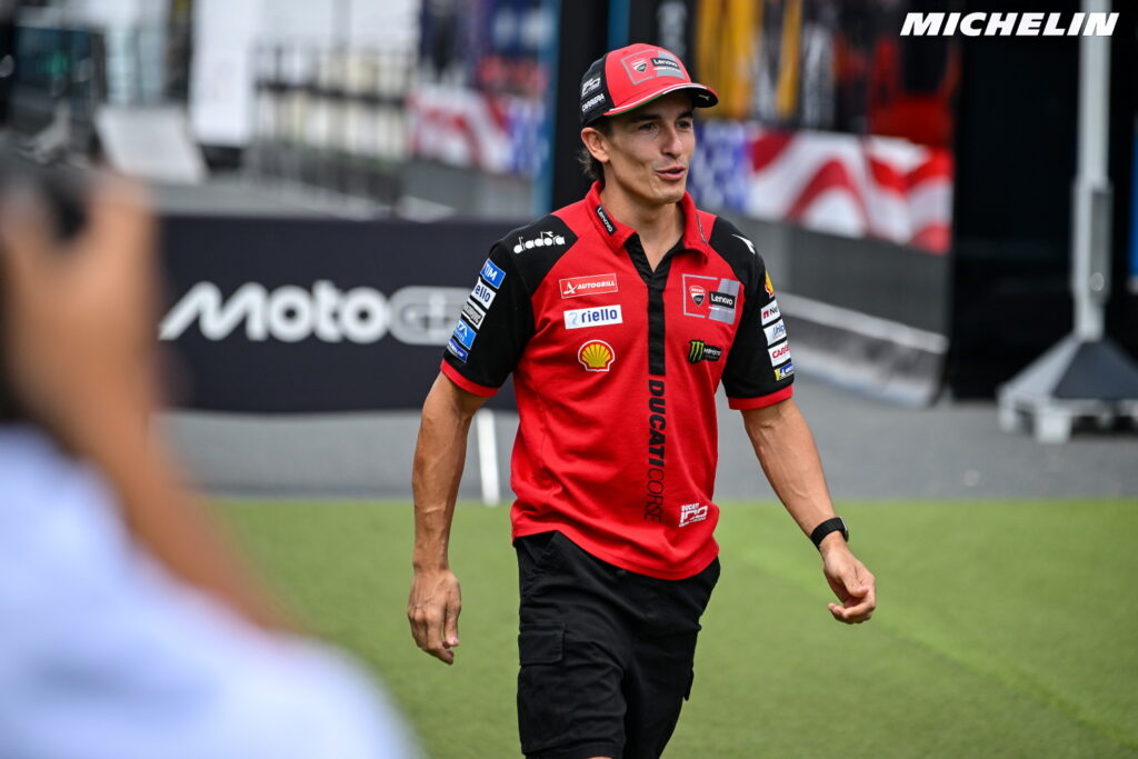 Marc Márquez em ação na sua moto Honda RC213V durante uma corrida de MotoGP em Sachsenring, destacando sua agressividade e técnica.