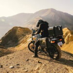 Motocicletas Royal Enfield Himalayan estacionadas em um acampamento base nas montanhas nevadas do Himalaia, em Ladakh, Índia, durante uma experiência de aventura off-road.
