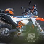 Imagem de perfil da nova KTM 690 Rally, moto de aventura monocilíndrica com carenagem de rally, tanques de combustível estendidos e suspensões de longo curso, focada em desempenho off-road.