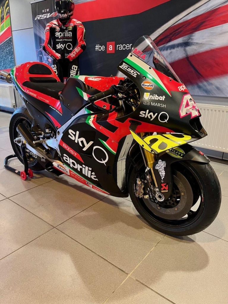 Aprilia RS-GP20 de corrida, uma motocicleta de MotoGP em plena pista, pilotada por Aleix Espargaró, destacando seu design aerodinâmico e a pintura de fábrica.