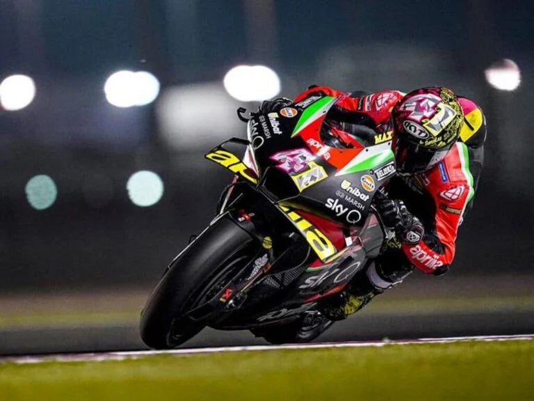 Aprilia RS-GP20 de corrida, uma motocicleta de MotoGP em plena pista, pilotada por Aleix Espargaró, destacando seu design aerodinâmico e a pintura de fábrica.