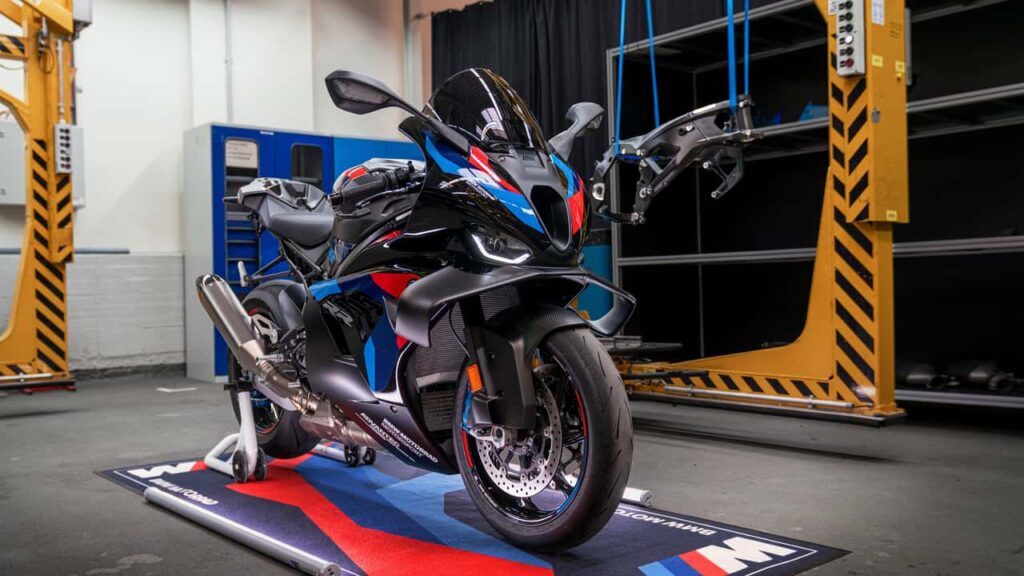 BMW M 1000 RR 2027 em alta velocidade na pista, exibindo seu design aerodinâmico e novas cores vibrantes, simbolizando as atualizações da linha de motos BMW.
