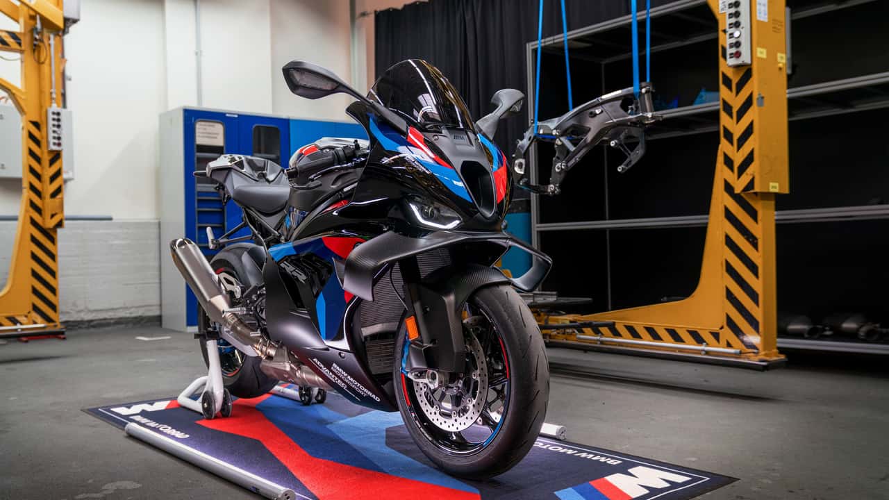 BMW M 1000 RR 2027 em alta velocidade na pista, exibindo seu design aerodinâmico e novas cores vibrantes, simbolizando as atualizações da linha de motos BMW.