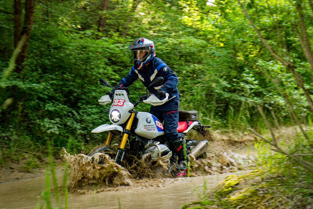 BMW R 12 G/S GS Trophy Competition Bike em ação off-road em terreno rochoso com cenário montanhoso ao fundo, pronta para o BMW GS Trophy 2026.