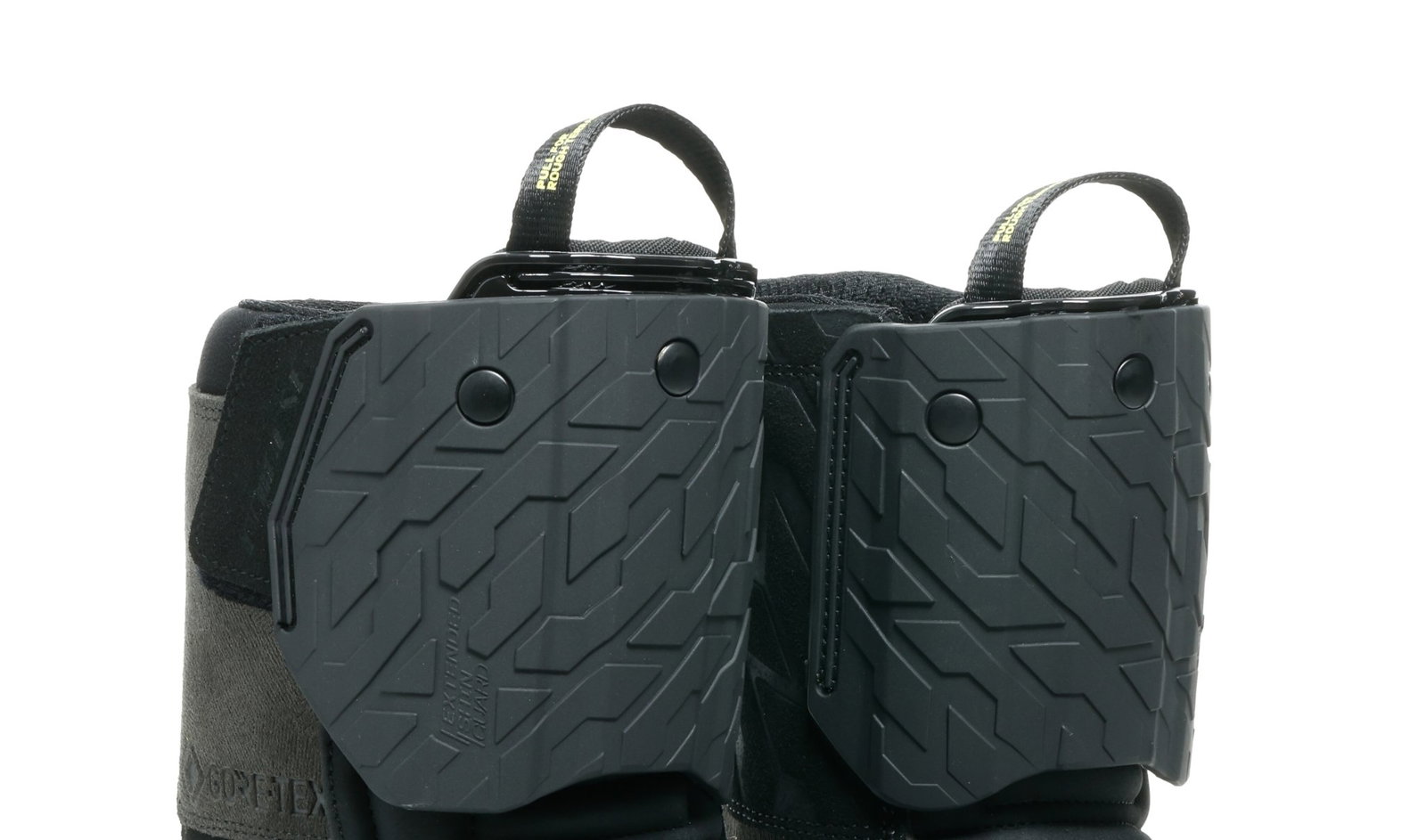 Par de botas Dainese Overyond XT GTX em destaque, mostrando o inovador sistema de proteção de canela ajustável, design robusto e membrana Gore-Tex.