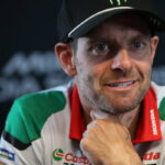 Cal Crutchlow em sua moto de corrida Yamaha YZR-M1 em alta velocidade na pista de Silverstone, demonstrando foco e experiência.