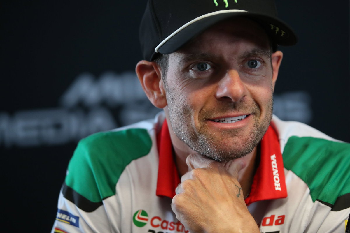 Cal Crutchlow em sua moto de corrida Yamaha YZR-M1 em alta velocidade na pista de Silverstone, demonstrando foco e experiência.