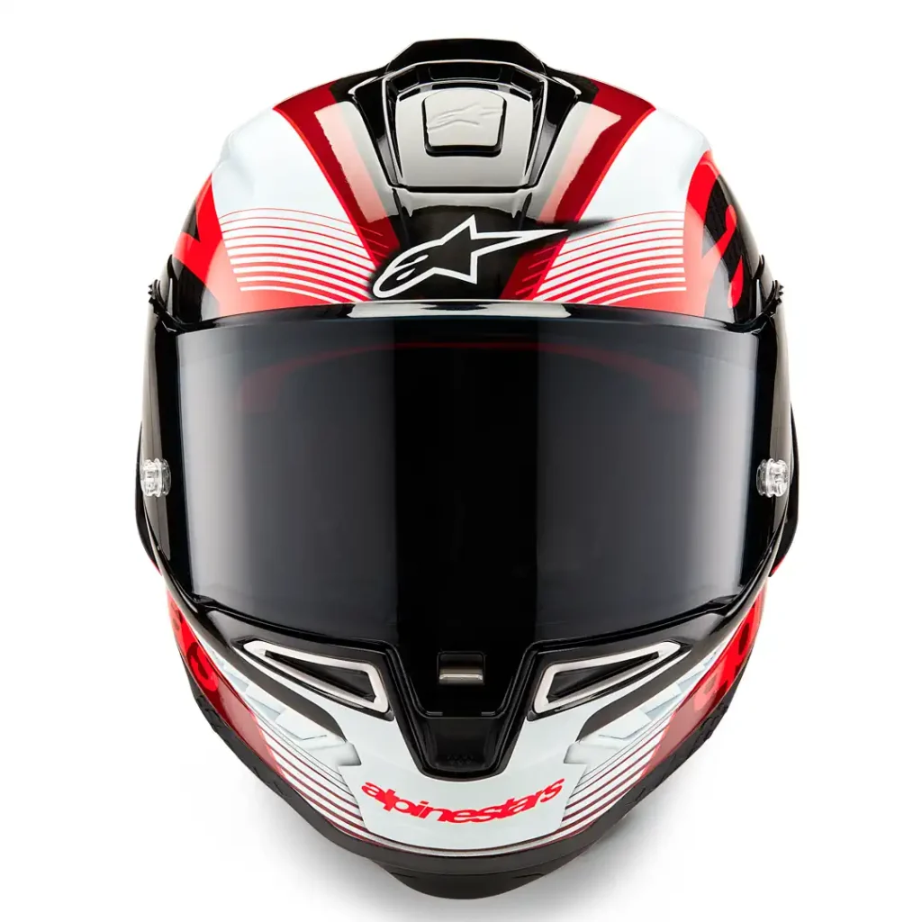 Detalhe do Capacete Alpinestars Supertech R10 em fibra de carbono, exibindo suas linhas aerodinâmicas e sistema de ventilação para performance em pista e rua.