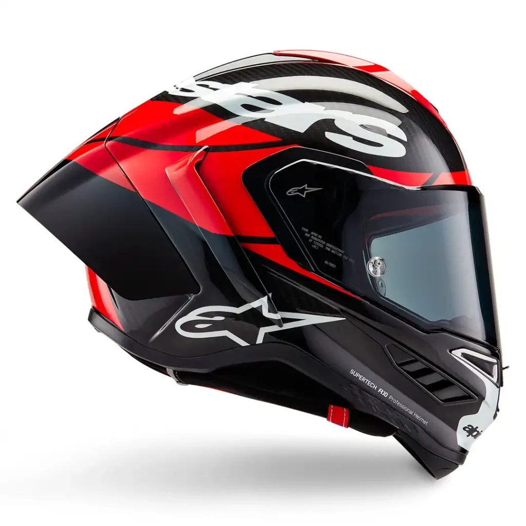 Detalhe do Capacete Alpinestars Supertech R10 em fibra de carbono, exibindo suas linhas aerodinâmicas e sistema de ventilação para performance em pista e rua.