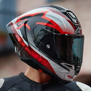 Detalhe do Capacete Alpinestars Supertech R10 em fibra de carbono, exibindo suas linhas aerodinâmicas e sistema de ventilação para performance em pista e rua.