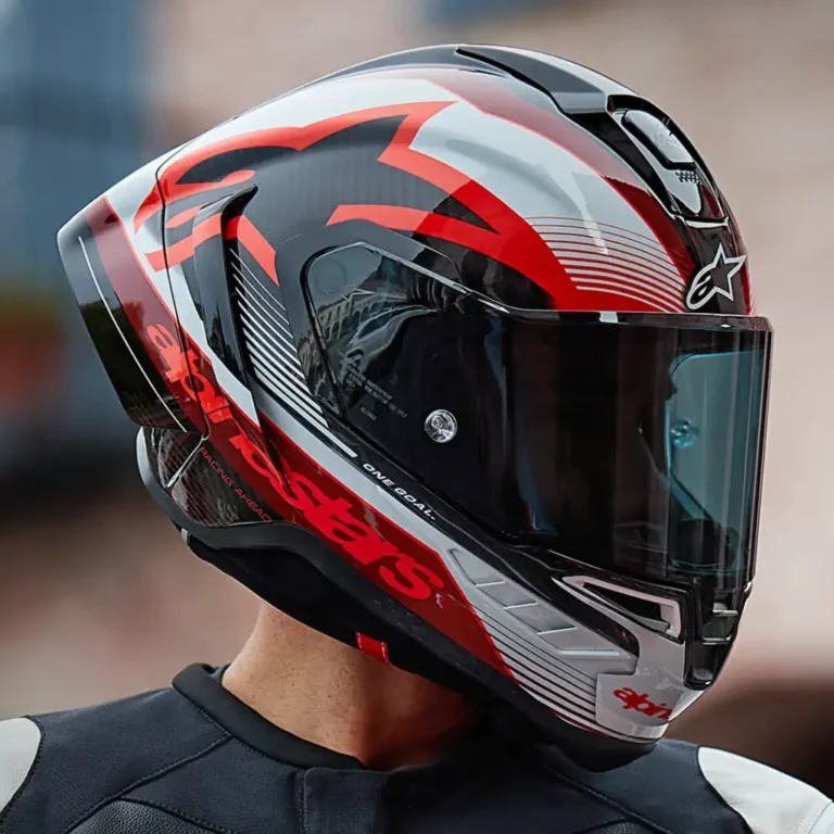Detalhe do Capacete Alpinestars Supertech R10 em fibra de carbono, exibindo suas linhas aerodinâmicas e sistema de ventilação para performance em pista e rua.