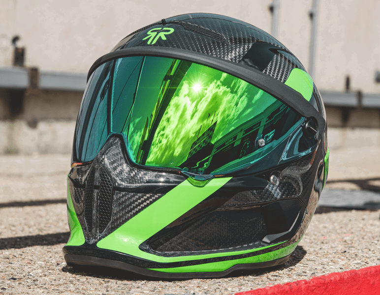 Detalhe lateral do Capacete Ruroc AT4 Track Verde de edição limitada, mostrando a carcaça de fibra de carbono e o grafismo vibrante com detalhes em verde.
