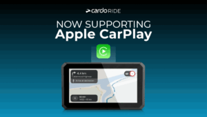 Motociclista visualizando informações do aplicativo Cardo Ride Pro integrado ao Apple CarPlay no painel digital de uma motocicleta moderna, com navegação e música.