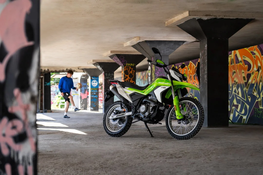 Imagem de destaque da CFMoto 250 Dual em um cenário de trilha leve, mostrando seu design aventureiro e robustez para uso misto.