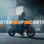 KTM 790 Duke 2027 em alta velocidade, demonstrando agilidade e controle em uma curva de estrada sinuosa, com o piloto inclinado na moto.