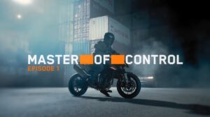 KTM 790 Duke 2027 em alta velocidade, demonstrando agilidade e controle em uma curva de estrada sinuosa, com o piloto inclinado na moto.