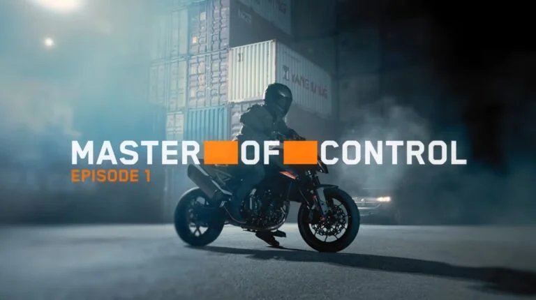 KTM 790 Duke 2027 em alta velocidade, demonstrando agilidade e controle em uma curva de estrada sinuosa, com o piloto inclinado na moto.