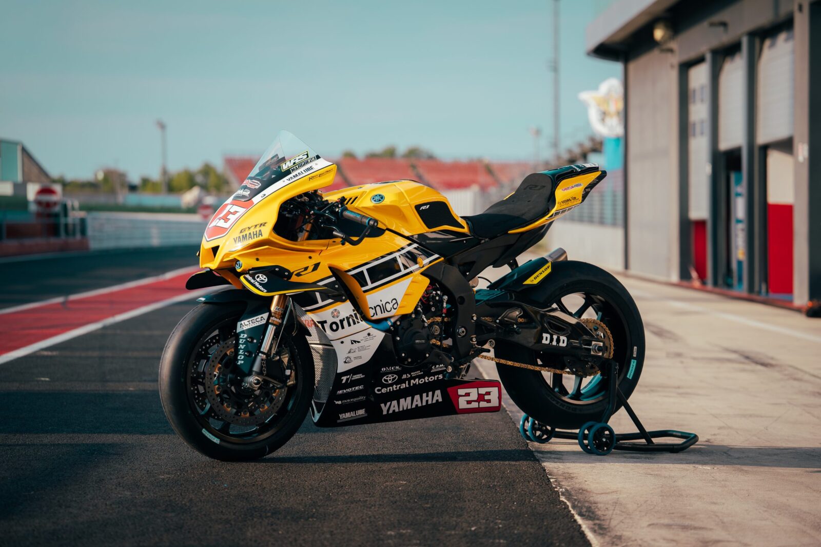 Detalhe da Yamaha R1 Superbike da equipe Yamaha DMR Racing com a pintura amarela e preta clássica de Kenny Roberts no Misano World Circuit.