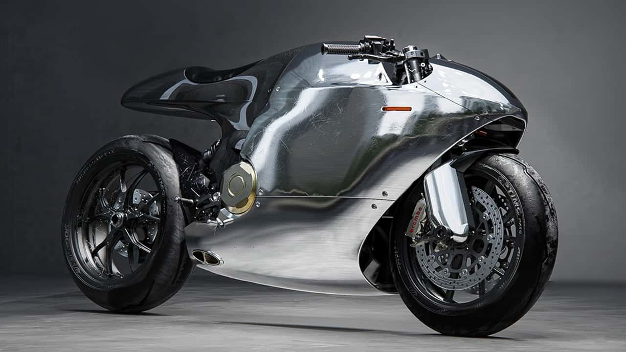 Uma visão lateral da motocicleta customizada Bandit9 Liquid Metal Ducati Monster 821, destacando seu design futurista e carenagem prateada, com detalhes em bronze e acabamento de alta qualidade.