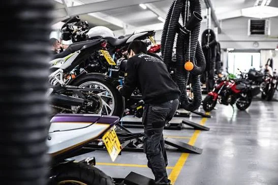 Vista panorâmica de uma grande concessionária de motocicletas usadas, SuperBike Factory, com centenas de motos de diversas marcas e modelos expostas no showroom. Detalhe da organização e iluminação do espaço.
