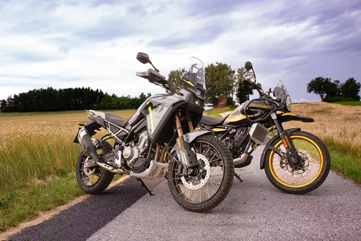 Uma linha de motocicletas de diversas marcas e origens, incluindo modelos japoneses, europeus e chineses, estacionadas em frente a uma paisagem urbana, simbolizando a diversidade e a competitividade do mercado global de duas rodas. Destaque para a qualidade e design moderno.