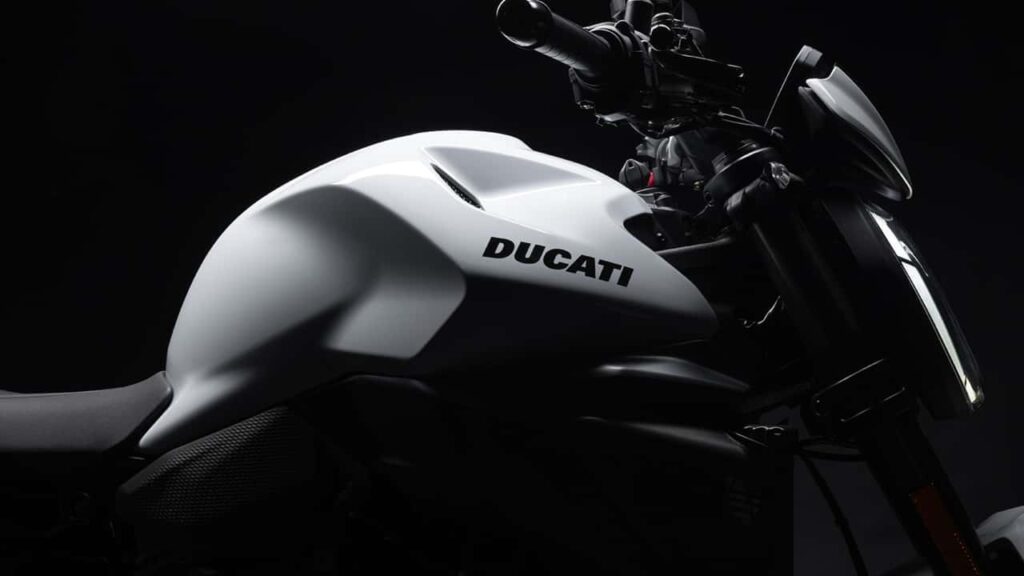 Imagem panorâmica da fábrica da Ducati em Borgo Panigale, na Itália, com motocicletas de alta performance em destaque, representando a excelência e tradição da marca.