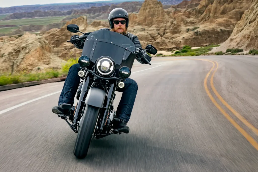 Harley-Davidson Deadwood 2026 estacionada, destacando seu acabamento Denim Black e o design clássico da linha Softail, ideal para pilotos que buscam tradição.