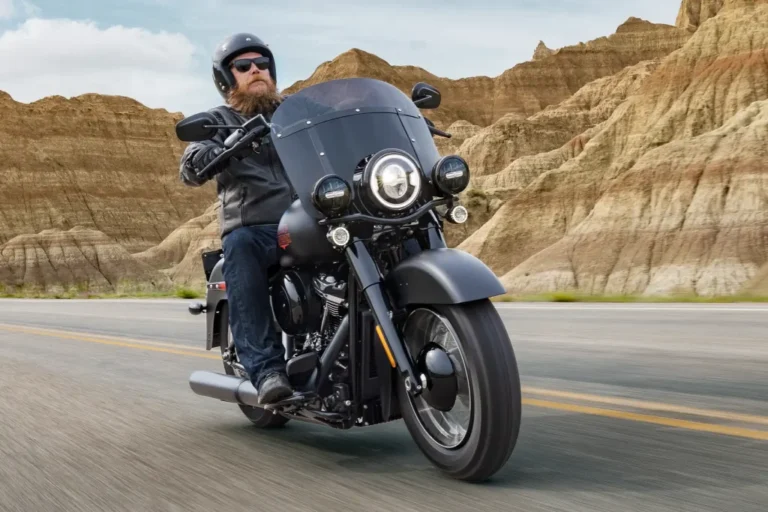 Harley-Davidson Deadwood 2026 estacionada, destacando seu acabamento Denim Black e o design clássico da linha Softail, ideal para pilotos que buscam tradição.