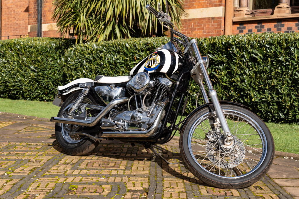 Harley-Davidson personalizada com tema do Newcastle United, pertencente ao lendário jogador Kevin Keegan, exibida antes de um leilão.