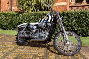 Harley-Davidson personalizada com tema do Newcastle United, pertencente ao lendário jogador Kevin Keegan, exibida antes de um leilão.