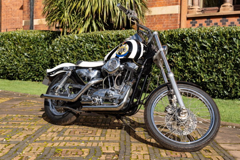 Harley-Davidson personalizada com tema do Newcastle United, pertencente ao lendário jogador Kevin Keegan, exibida antes de um leilão.