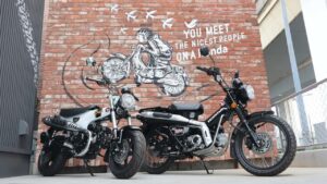 Fachada moderna e convidativa do Honda Cub House no Japão, exibindo motocicletas personalizadas e um ambiente de cafe.