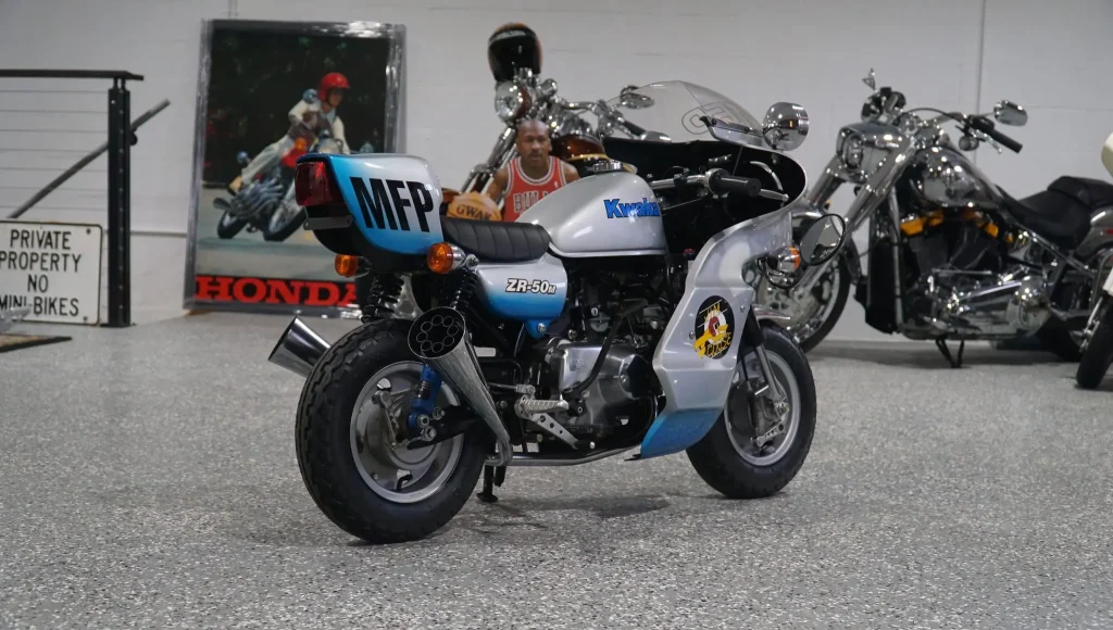 Honda Monkey 1986 customizada no estilo Mad Max, com pintura preta e detalhes cromados, inspirada na lendária motocicleta de Jim Goose, o policial de Mad Max.