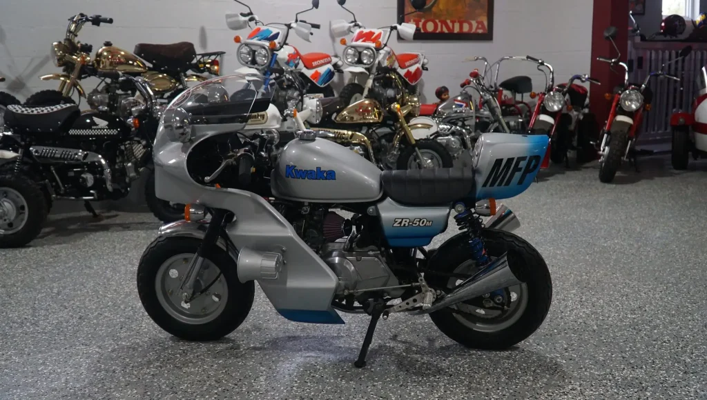 Honda Monkey 1986 customizada no estilo Mad Max, com pintura preta e detalhes cromados, inspirada na lendária motocicleta de Jim Goose, o policial de Mad Max.