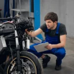 Motociclista europeu apresentando sua moto para inspeção técnica periódica, com inspetor verificando componentes de segurança.