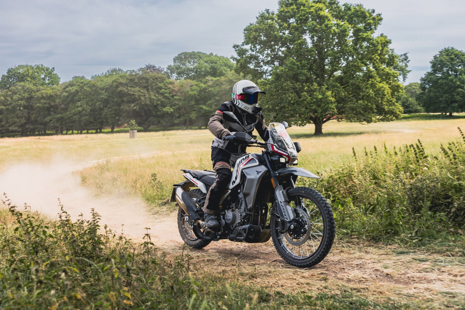 Renderização patenteada da motocicleta Kove 350 Rally em um ambiente off-road, destacando seu design robusto e características de rally.