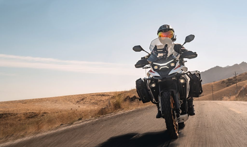 Kove 625X Pro em destaque, uma motocicleta crossover de média cilindrada com design moderno e preparada para aventura, em um cenário off-road.