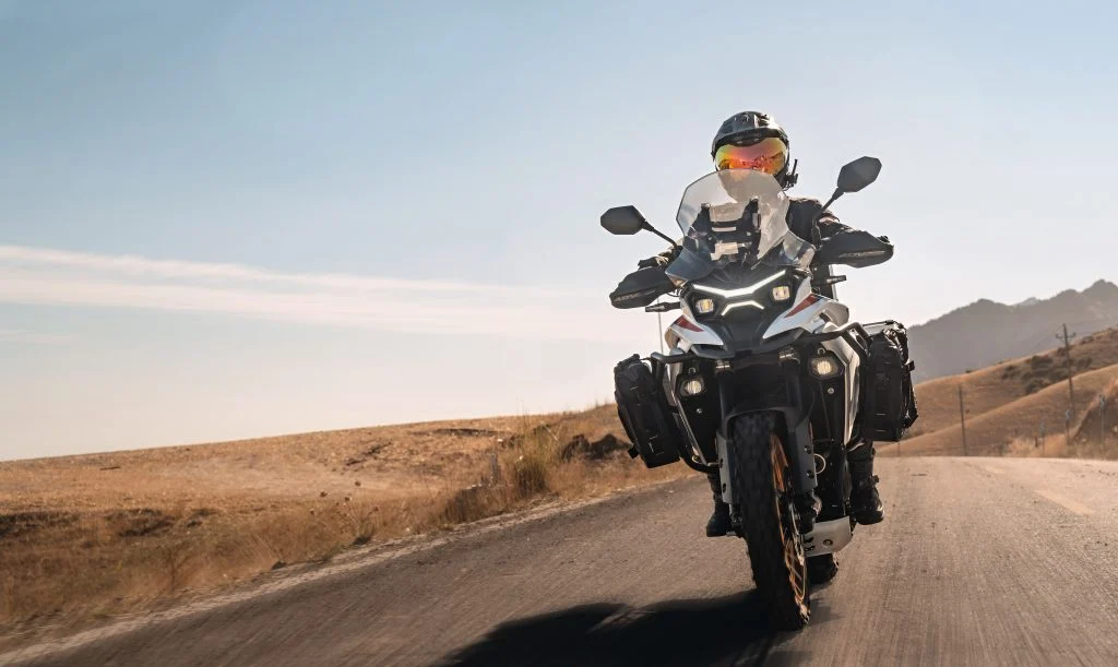 Kove 625X Pro em destaque, uma motocicleta crossover de média cilindrada com design moderno e preparada para aventura, em um cenário off-road.