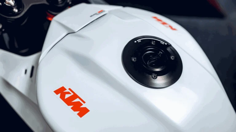 Moto esportiva KTM em alta velocidade em pista de corrida, destacando design agressivo e performance que remete ao MotoGP.