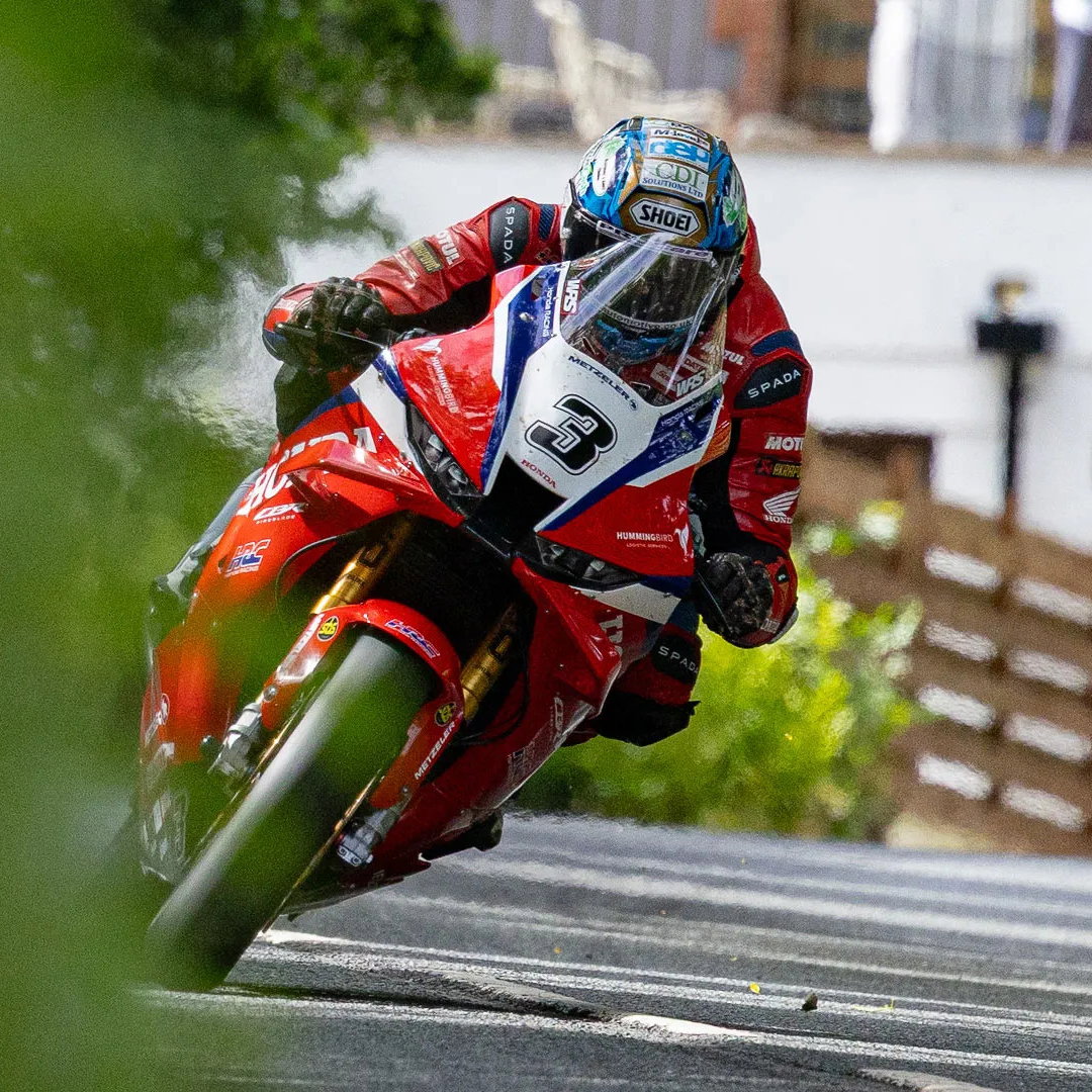 Maria Costello, piloto experiente, no comando de sua motocicleta de sidecar durante uma corrida desafiadora do Isle of Man TT em alta velocidade.