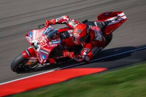 Marc Márquez pilotando sua moto de MotoGP em alta velocidade na pista de Sachsenring, Alemanha, durante a corrida Sprint, em uma curva acentuada e desafiadora.
