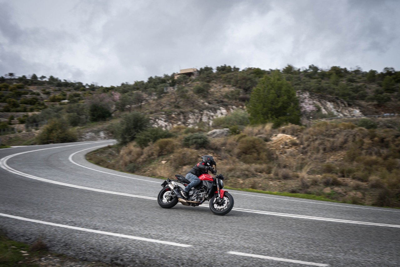 Motocicleta em uma estrada sinuosa nas montanhas dos Pireneus na Espanha, ao pôr do sol, destacando a beleza das melhores viagens de moto na Europa.
