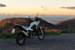 Motocicleta em uma estrada sinuosa nas montanhas dos Pireneus na Espanha, ao pôr do sol, destacando a beleza das melhores viagens de moto na Europa.